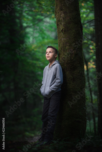 adorable boy stands in dense forests