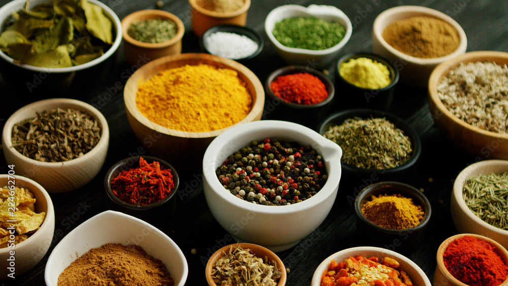 From above view of many little bowls with different kinds of spices laid on wooden background From above view of many little bowls with different kinds of spices laid on wooden background