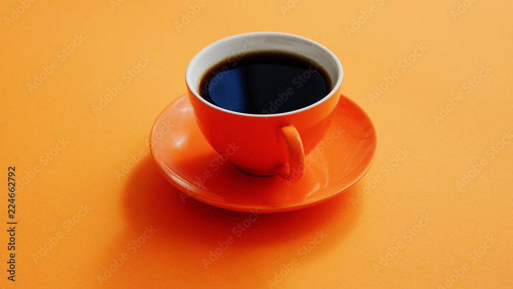 From above view of cup with hot black coffee on orange background From above view of cup with hot black coffee on orange background