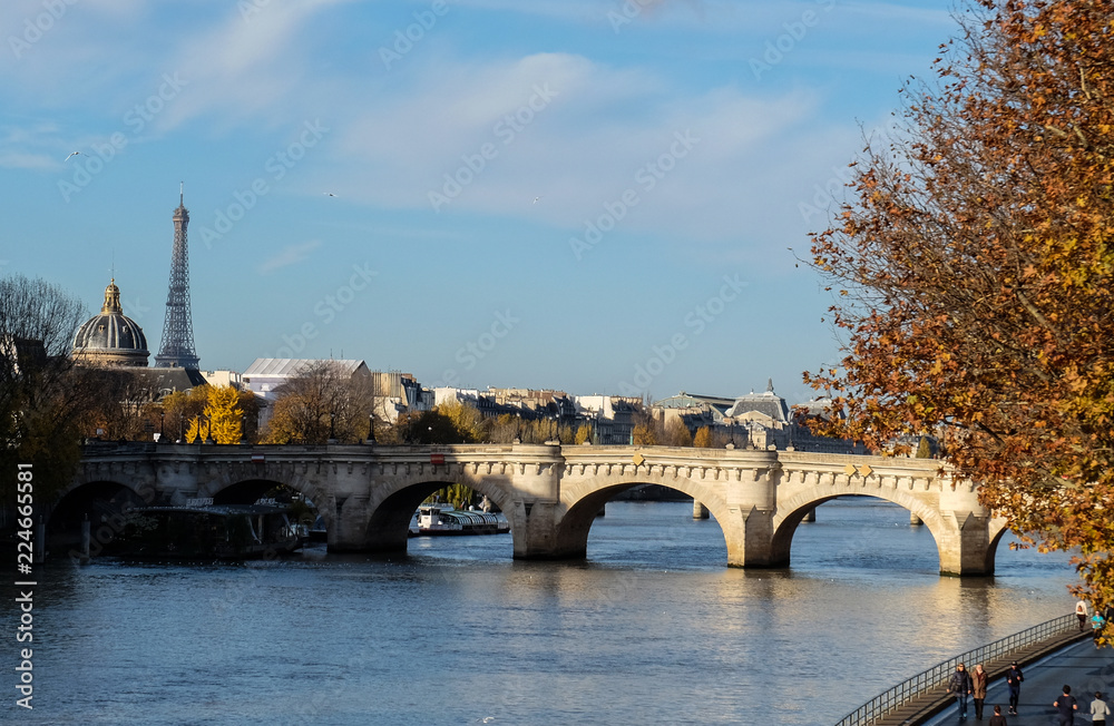  Paris in Autumn. The sun lights the river Seine, the turned yellow trees ashore and beautiful houses which make an architectural complex of the embankment