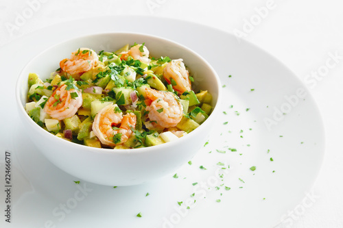 mayonnaise based salad with seafood, avocado, cucumber, and egg decorated with parsley