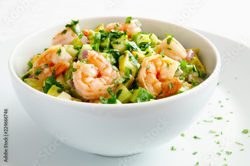 mayonnaise based salad with prawns, avocado, cucumber, and egg decorated with parsley