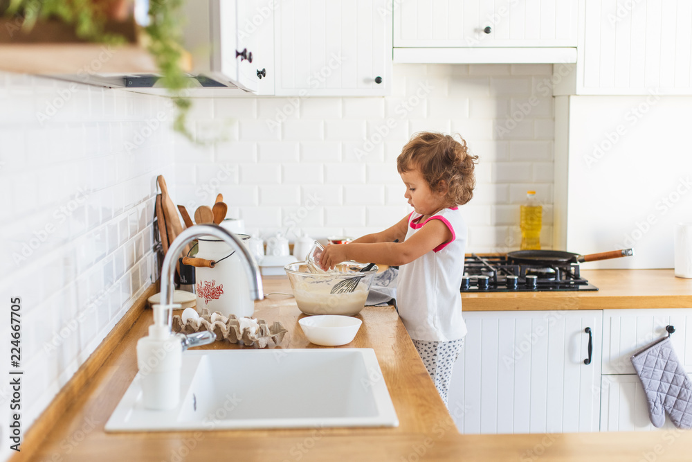 3 years cute girl preparing dough for pancakes at the kitchen. 3 years cute girl preparing dough for pancakes at the kitchen.