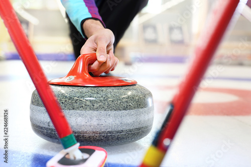 Zawodnicy grają w curling na torze curlingowym. Fototapet