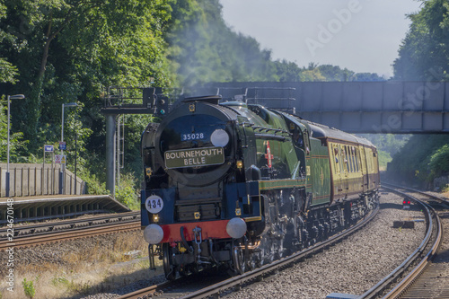 Clan Line. A Merchant Navy Class Steam locomotive speeds through Farnborough Station , Hampshire on 5th July, 2017. with The Bournemouth Belle