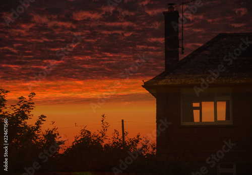 Dramatic red sunset and house