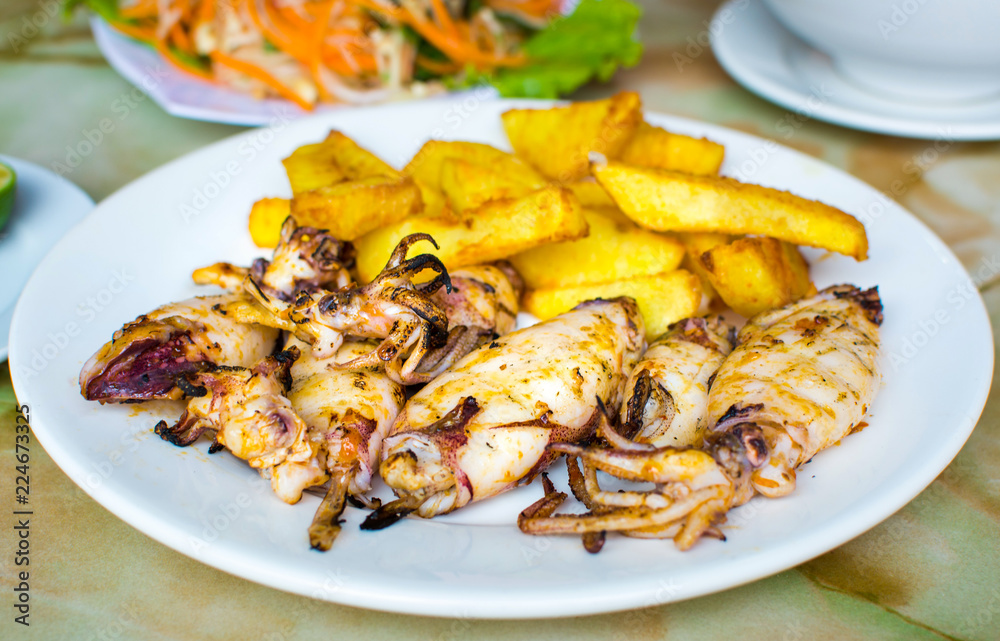 Grilled squid with french fries on a plate Grilled squid with french fries on a plate