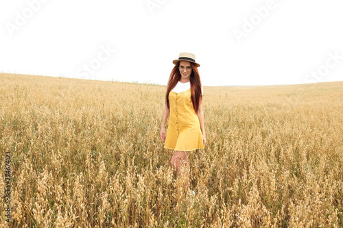 girl with red hair in the autumn field of wheat