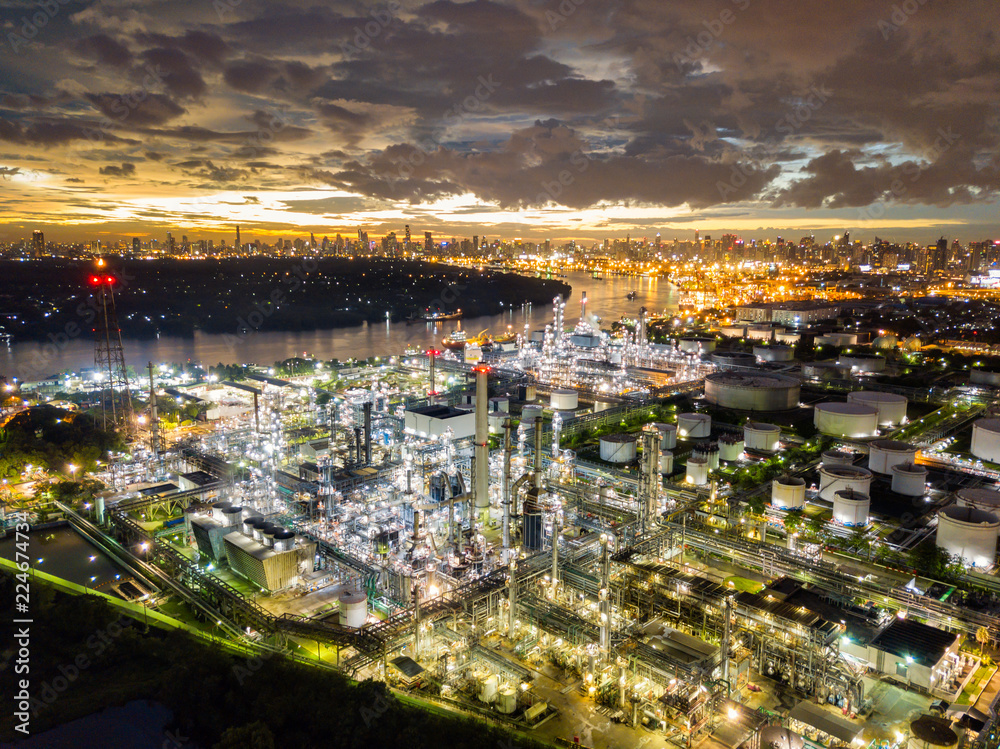 Aerial view of oil refinery near international port at night. Panorama of refinery plant at sunset. refinery factory and tank