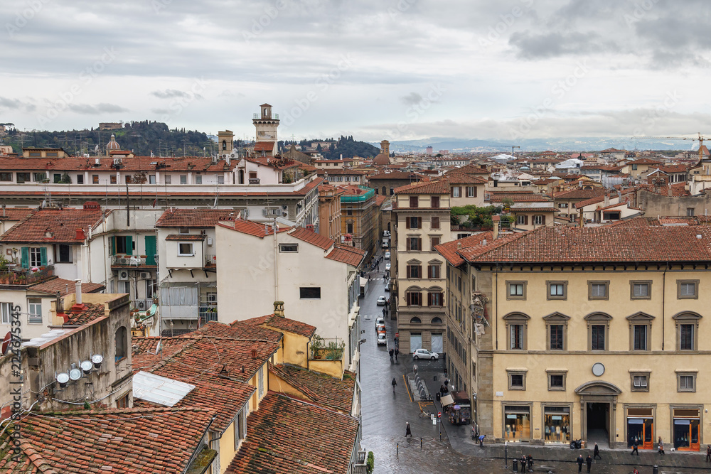 Red tiled roofs and narrow streets of Florence against the background of a cloudy sky