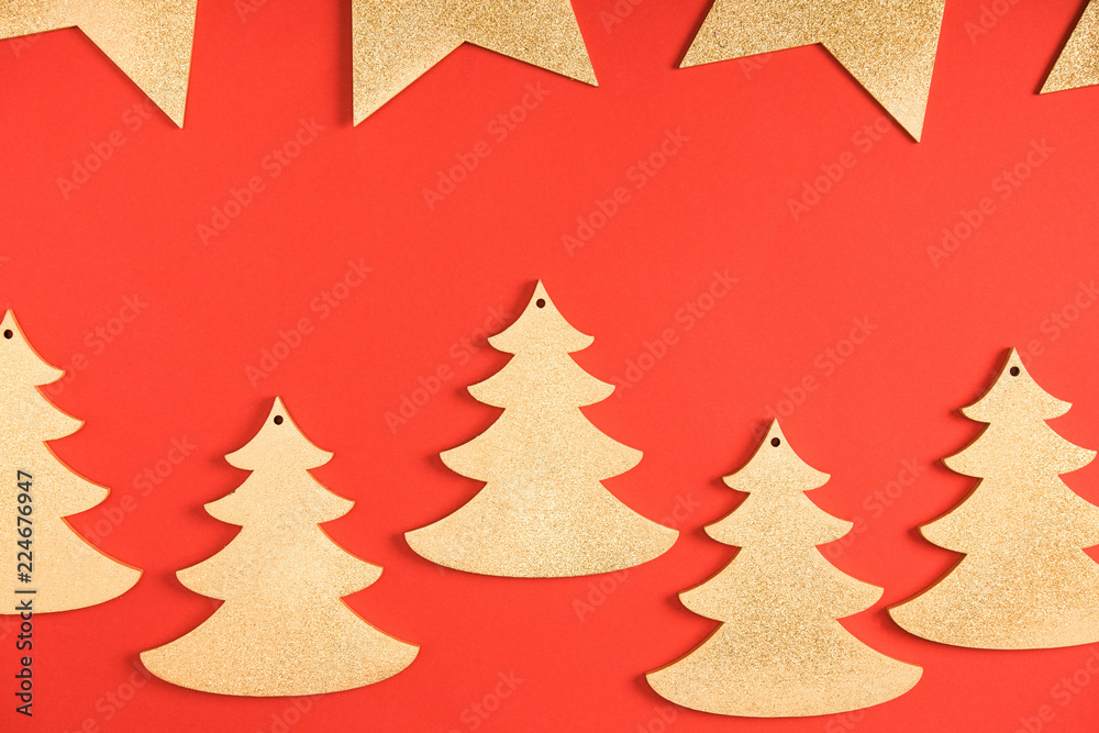 top view of golden stars and fir trees symbols on red background top view of golden stars and fir trees symbols on red background