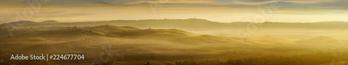 Idyllic view  foggy Tuscan hills in light of the rising sun