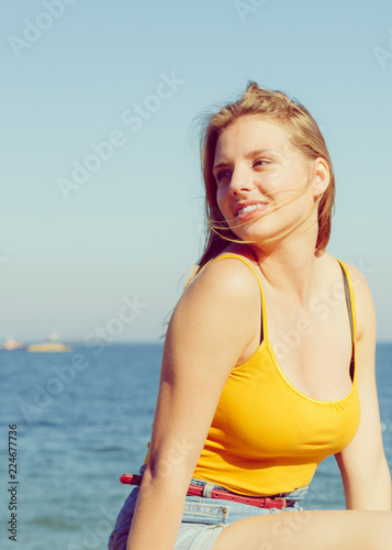 Lovely blonde girl relaxing outdoor by seaside