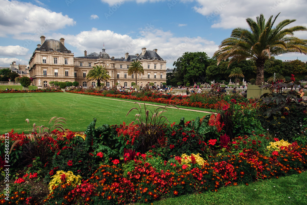 Fototapeta premium Paris, France - August 13, 2017. View of Luxembourg gardens and Luxembourg Palace, now is home to French Senate. Popular parisian landmark and famous public park with historic building and flowerbed.