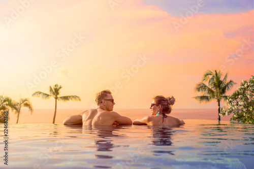 Happy couple on honeymoon in luxury hotel pool photo