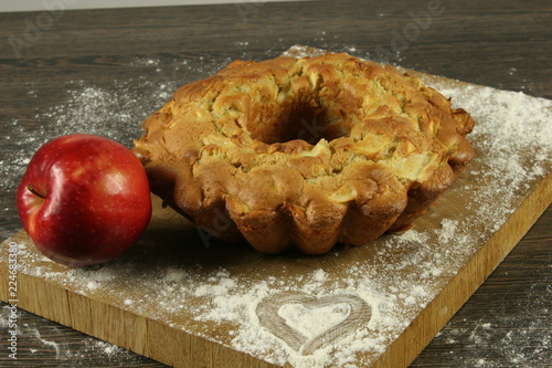 Homemade apple pie with a knitted cloth on wooden table
