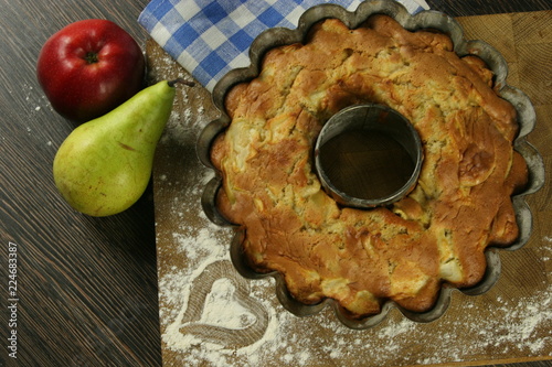 Homemade apple pie with a knitted cloth on wooden table