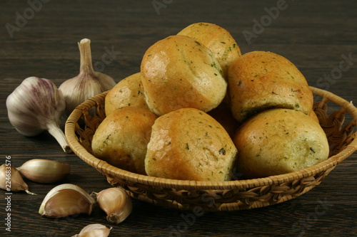 Homemade buns with garlic and dill on wooden table