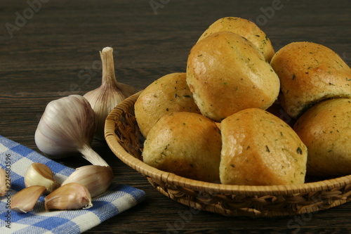 Homemade buns with garlic and dill on wooden table