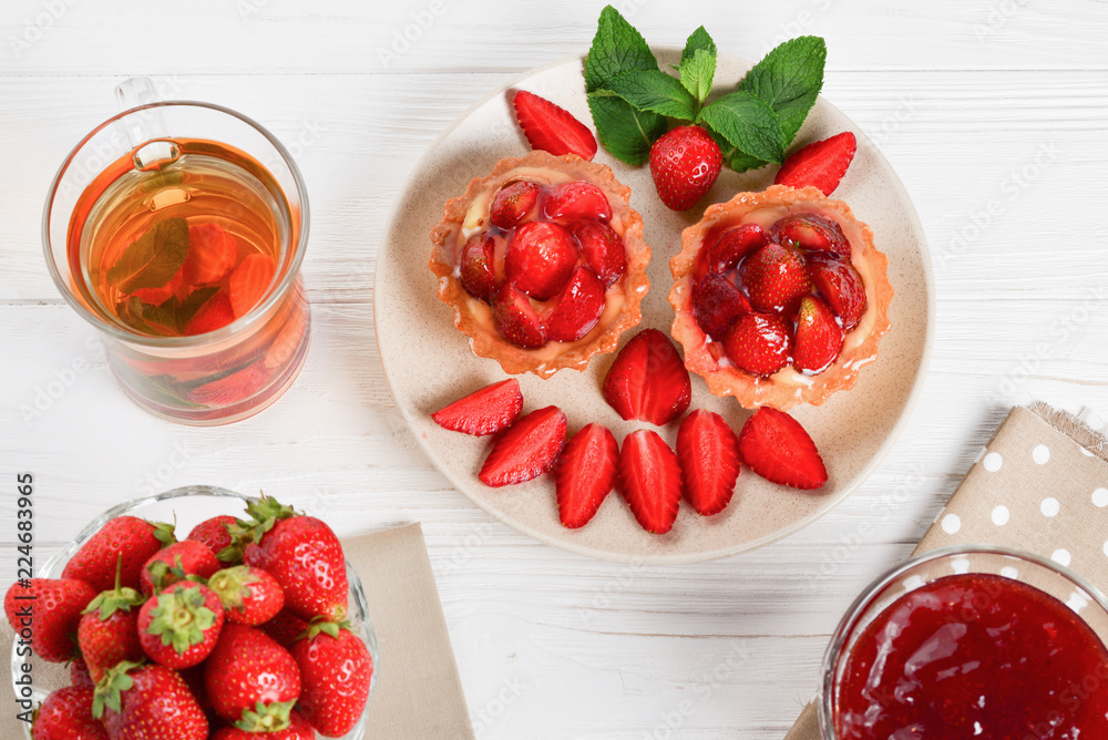 Tea drinking with tartlets and cakes with strawberries Tea drinking with tartlets and cakes with strawberries