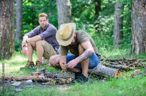 Camping in forest. Men on vacation. Man brutal bearded hipster prepares bonfire in forest. Ultimate guide to bonfires. Arrange the woods twigs or wood sticks. How to build bonfire outdoors © be free