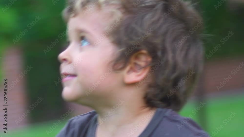 Two little brothers playing with blonde hair and blue eyes, running and laughting in the garden