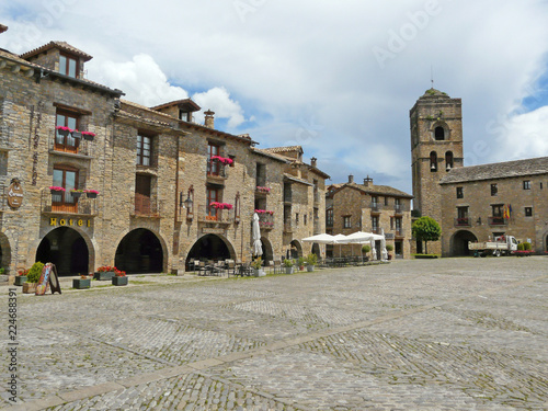 Plaza de la iglesia del pueblo medieval de Ainsa (Huesca) con sus antiguos soportales y casas de piedra