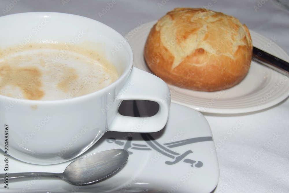 Tasse Kaffee und Brötchen auf einem gedeckten Tisch Tasse Kaffee und Brötchen auf einem gedeckten Tisch