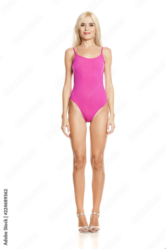 young pretty blonde woman posing in pink sweamsuit on white background young pretty blonde woman posing in pink sweamsuit on white background
