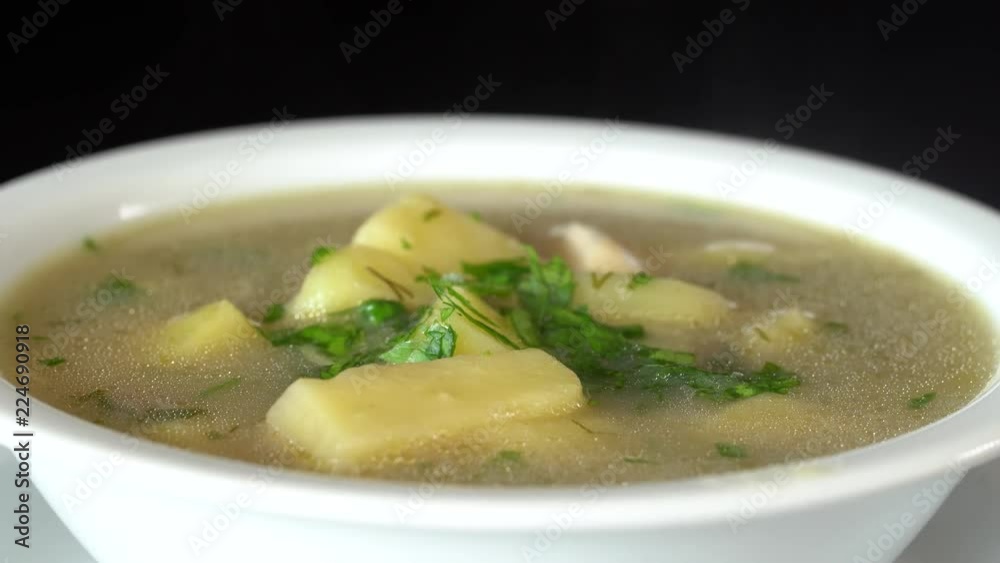 Vegetable soup with mushrooms and potatoes. Healthy food, mushrooms soup in white plate, close up, rotates Vegetable soup with mushrooms and potatoes. Healthy food, mushrooms soup in white plate, close up, rotates