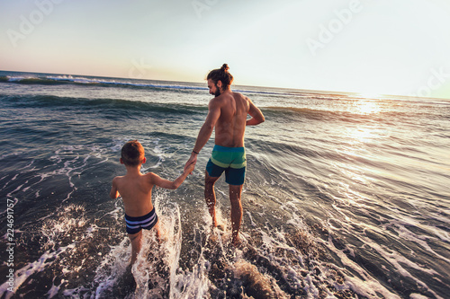 Father and son playing on the beach at the day time