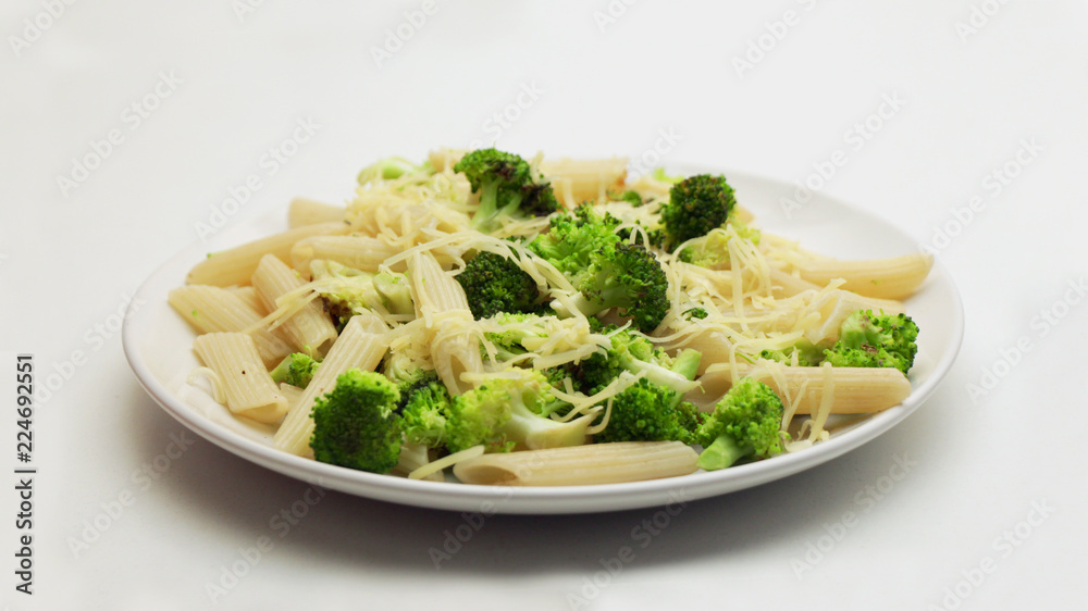 Pasta with Broccoli and Grated Cheese on a White Plate on a White Background