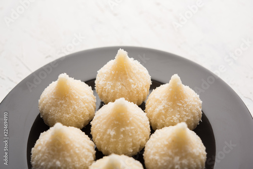 Sweet Modak made using coconut, khoya and sugar. Popular Maharashtrian recipe offered to lord Ganesha in Ganesh Festival. Served in a plate. Selective focus photo