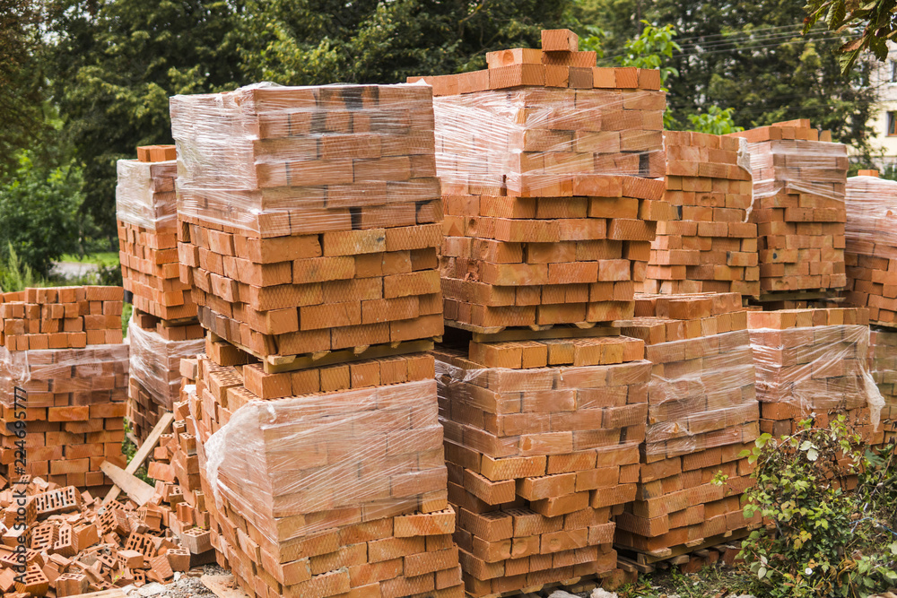 Stack of red brick for construction. Common quality building bricks stacked ready for use. Stack of red brick for construction. Common quality building bricks stacked ready for use.
