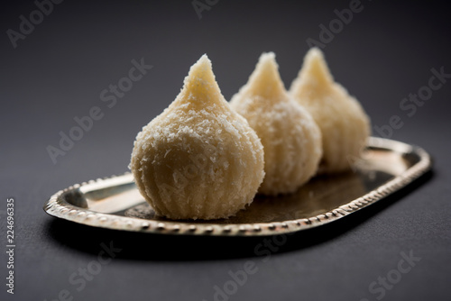 Sweet Modak made using coconut, khoya and sugar. Popular Maharashtrian recipe offered to lord Ganesha in Ganesh Festival. Served in a plate. Selective focus photo