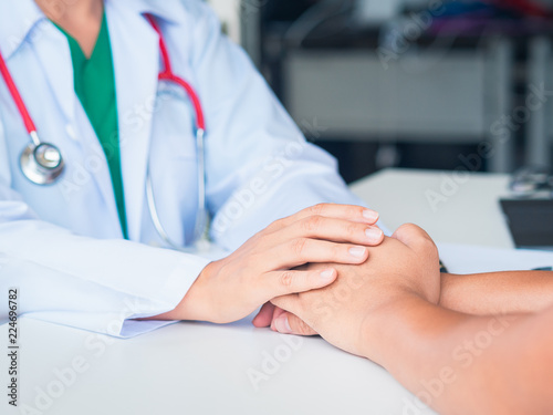 Hand of doctor reassuring her patient. Medical ethics and trust concept.