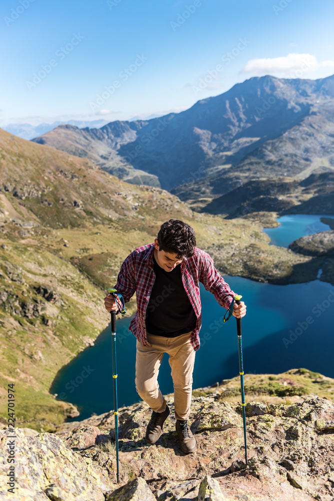 Men travel man standing on high mountain, hiking trip. Tristaina high mountain lakes in Pyrenees. Andorra