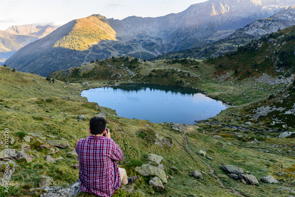 Men travel man standing on high mountain, hiking trip. Tristaina high mountain lakes in Pyrenees. Andorra Men travel man standing on high mountain, hiking trip. Tristaina high mountain lakes in Pyrenees. Andorra