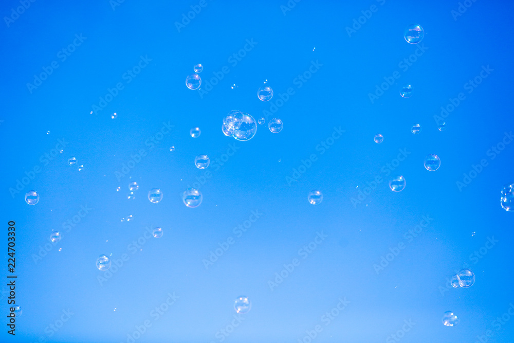Soap bubbles in flight against the blue sky