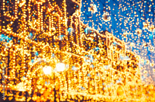 Bright Christmas Street Illumination on the facade of the buildings. The City is Decorated for the Christmastide Holiday. New Year Lights Decorating Shimmering bokeh