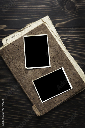 Brown book  with old frame photo on wood table background