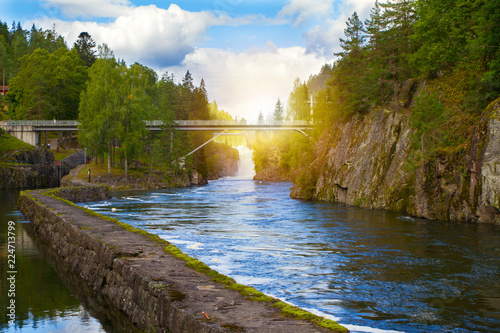Bridge above the river and waterfall. View of the Telemark Canal with old locks - tourist attraction in Skien, Norway photo