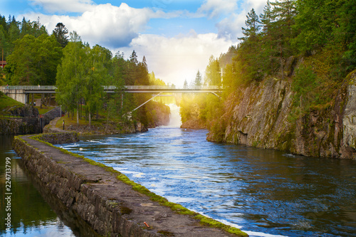 Bridge above the river and waterfall. View of the Telemark Canal with old locks - tourist attraction in Skien, Norway