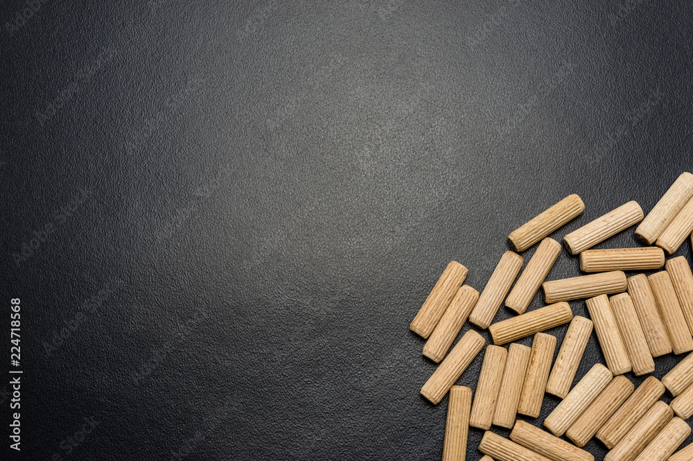 A lot of wooden pegs lying flat on a black background. A lot of wooden pegs lying flat on a black background.