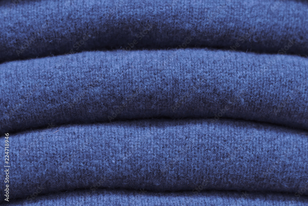 Stack of trend Sargasso Sea woolen sweaters close-up, texture, background Stack of trend Sargasso Sea woolen sweaters close-up, texture, background