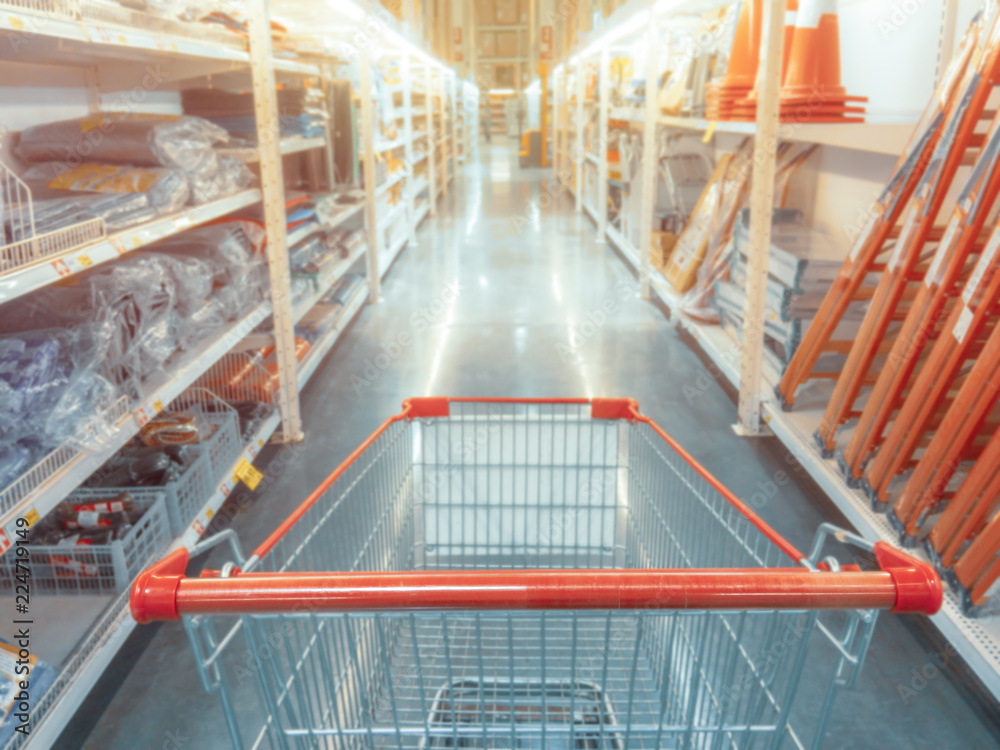 Abstract blurred photo of hardware store with empty shopping cart. - obrazy, fototapety, plakaty 