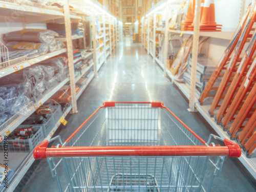 Abstract blurred photo of hardware store with empty shopping cart.
