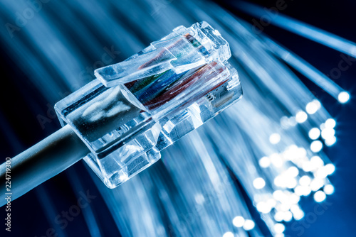 Network cable and optical fibers with lights in the ends. Blue background.