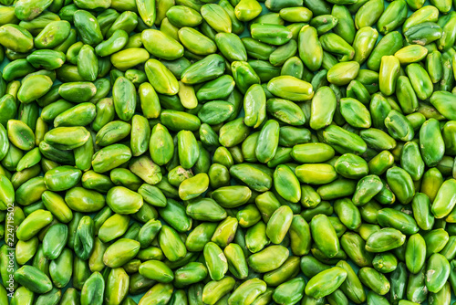 Lot of green pistachio nuts. Food background. photo