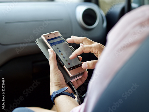 Eine junge Frau verwendet ihr Smartphone als Beifahrer in einem Auto